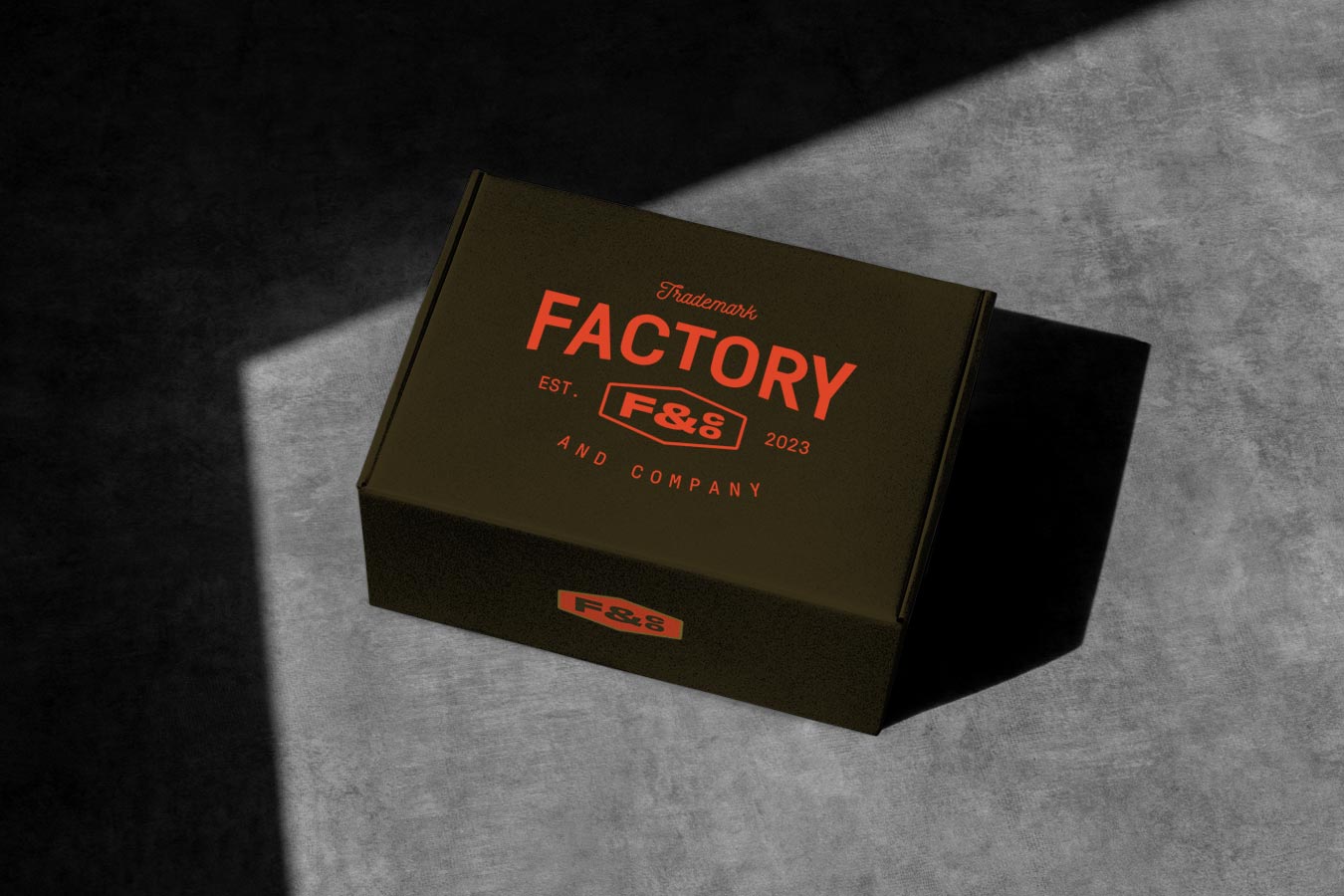 A dark-green box with the orange Factory logo on top, placed on a granite countertop.