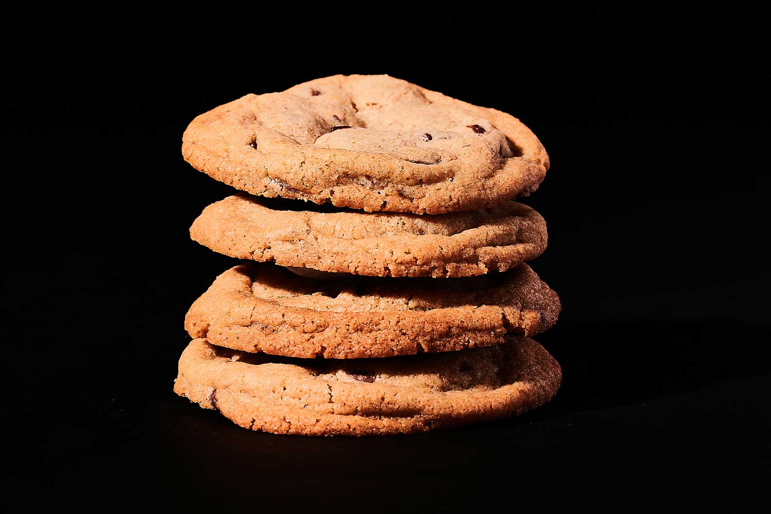 Four chocolate chip cookies stacked vertically.